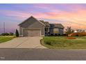 Beautiful home featuring manicured lawn, lovely landscaping, and a large driveway under a colorful sunset at 25 Cornfield Ln, Benson, NC 27504