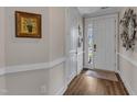 Inviting entryway featuring hardwood floors, white trim, and a stylish front door at 2528 Forge Village Way, Apex, NC 27523