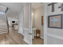 Hallway view featuring hardwood floors, white trim, half bath, and staircase at 2528 Forge Village Way, Apex, NC 27523