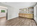 A living area featuring a wood floor and a wooden wall unit with shelves and cabinets at 2904 Falkirk Pl, Raleigh, NC 27604