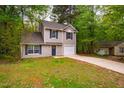 Charming two-story home featuring neutral siding, blue shutters, and a welcoming front door with a decorative wreath at 3 Little Stone Cir, Durham, NC 27703
