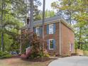 Brick home with blue shutters, mature landscaping, and a paved driveway at 301 Trappers Sack Rd, Cary, NC 27513