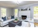 Bright living room with white sofas, fireplace, and natural light from large windows at 301 Trappers Sack Rd, Cary, NC 27513