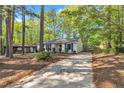 Traditional single-story house with blue shutters, a long driveway and mature trees at 3116 Henslowe Dr, Raleigh, NC 27603