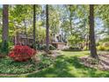 Lovely home surrounded by lush greenery, mature trees, and colorful flower beds at 3117 Woodgreen Dr, Raleigh, NC 27607