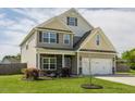 Beautiful two-story home boasts a manicured lawn, complemented by lush landscaping and mature trees at 312 Loon Ct, Graham, NC 27253