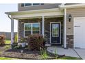 Inviting front entrance with stone accents, manicured shrubs, and a well-lit porch, number 312 at 312 Loon Ct, Graham, NC 27253