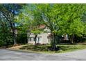 Charming two-story home featuring a blue front door, neutral siding, and black shutters, set amidst mature trees and green lawn at 3317 E Jameson Rd, Raleigh, NC 27604