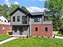 Charming two-story home with gray siding, a red brick accent, and a well-manicured lawn at 337 Merrywood Dr, Raleigh, NC 27610