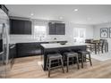 Bright kitchen boasts black cabinets, a white countertop island, and seamless access to the dining area at 368 N Coral Bells Way, Four Oaks, NC 27524