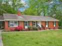 Charming single-story brick home with lush front lawn and mature trees at 3806 Sue Ln, Raleigh, NC 27604