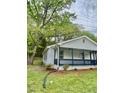 Side view of home with a cozy front porch, lush lawn and landscaping featuring a well-maintained exterior at 409 Neathery St, Henderson, NC 27536