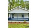 Front view of home featuring a cozy front porch with blue accents and well-kept landscaping at 409 Neathery St, Henderson, NC 27536