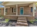 Charming brick home features a covered front porch and a teal-colored front door, enhancing its curb appeal at 419 Joy Dr, Garner, NC 27529