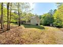 Well-maintained single story home with a spacious lawn and a detached shed, nestled among mature trees at 452 Dogwood Trl, Henderson, NC 27537