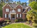 Charming brick home with a balcony and a well-maintained lawn and landscaping at 5016 Dillswood Ln, Raleigh, NC 27606