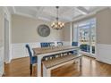 Formal dining room featuring hardwood floors, chandelier, wainscoting and coffered ceilings at 5109 Dove Forest Ln, Apex, NC 27539