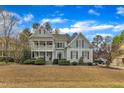 Stunning two-story house with a double porch, well-maintained lawn and beautiful blue skies at 5109 Dove Forest Ln, Apex, NC 27539