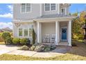 Charming home exterior boasts a covered front porch with rocking chairs and a blue front door at 512 Montague Ln, Raleigh, NC 27601