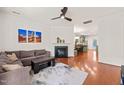 Comfortable living room with hardwood floors, a fireplace, and an open view to the dining area and kitchen at 607 Millbrook Dr, Pittsboro, NC 27312