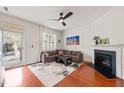 Bright living room featuring hardwood floors, a fireplace, a comfortable couch and an exterior door at 607 Millbrook Dr, Pittsboro, NC 27312
