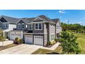 Charming townhome with gray siding, stone accents, and a two-car garage in a serene neighborhood at 608 Creekway Dr, Fuquay Varina, NC 27526
