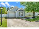 Attractive single-story home with light blue siding, attached garage, and concrete driveway at 611 Edenberry Dr, Durham, NC 27713