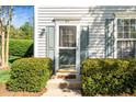 Cozy front porch with a glass storm door and verdant hedges framing the entryway, adding charm at 614 Canyon Lake Cir, Morrisville, NC 27560
