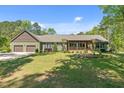 Backyard featuring a lush green lawn and an inviting covered porch with wooden beams at 626 Bailey Rd, Coats, NC 27521