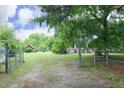 A long driveway leads to the charming two-story farmhouse with a red storage shed to the left at 7129 Dexter Rd, Oxford, NC 27565
