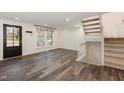 Bright living room with hardwood floors, stairs to the second floor, and front door at 7324 Summerland Dr, Raleigh, NC 27612