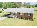 Inviting brick home with a covered front porch, lush lawn and mature trees at 7698 Nc Highway 222, Kenly, NC 27542