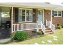 Charming brick home featuring a cozy covered porch with decorative plants and seating at 7698 Nc Highway 222, Kenly, NC 27542