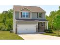 Two-story home features a two-car garage, neutral siding, and a well-maintained front yard at 80 Doonbeg Dr, Fuquay Varina, NC 27526