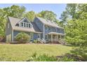 Beautiful two-story home with covered porch and attached garage nestled among mature trees at 8407 Millers Bnd, Bahama, NC 27503