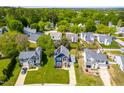 Aerial view of a blue and brick home with a well-kept lawn in a neighborhood with mature trees at 909 Starkland Way, Holly Springs, NC 27540