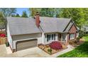 Aerial view of a well-maintained home featuring a large roof, attached garage, and mature landscaping at 910 S Third St, Mebane, NC 27302