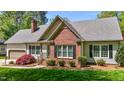 This charming home features a brick facade, complemented by manicured landscaping and a welcoming entrance at 910 S Third St, Mebane, NC 27302