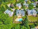 An aerial view showcases a home with a private backyard oasis, complete with a refreshing pool and wooden deck at 102 Traviliah Oaks Ln, Cary, NC 27518