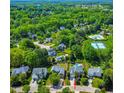 A neighborhood shot of a home with a community pool and tennis courts surrounded by lush greenery at 102 Traviliah Oaks Ln, Cary, NC 27518