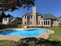Backyard featuring an inground pool, wooden deck, and well-maintained landscaping at 102 Traviliah Oaks Ln, Cary, NC 27518