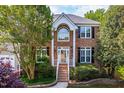 Exterior showcasing a brick facade, large windows, and manicured front yard at 102 Traviliah Oaks Ln, Cary, NC 27518