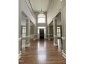 Grand foyer with a stunning chandelier, soaring ceilings, and dark wood flooring at 102 Traviliah Oaks Ln, Cary, NC 27518