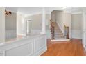 Inviting foyer with hardwood floors, staircase, and detailed white wainscoting at 103 Aisling Ct, Cary, NC 27513
