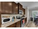 Kitchen with dark cabinets, stainless appliances, granite counters, and a breakfast area at 106 Neuse Bluff Cir, Clayton, NC 27527