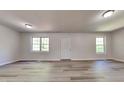 Open living room with modern flooring, neutral walls, and natural light from two windows at 109 Stone Ridge Dr, Smithfield, NC 27577