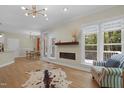 Open-concept living area with modern fireplace, hardwood floors, and large windows offering natural light at 110 Chapelwood Way, Cary, NC 27518