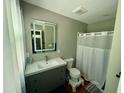 Bathroom with modern vanity, LED mirror, and shower-tub combination at 1102 Poplar Ave, Garner, NC 27529