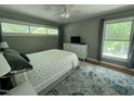 Well-lit bedroom featuring large windows, ceiling fan, and neutral decor at 1102 Poplar Ave, Garner, NC 27529