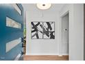 Bright foyer with a sleek blue door, modern art, and beautiful wood-look floors at 1124 Hardimont Rd, Raleigh, NC 27609